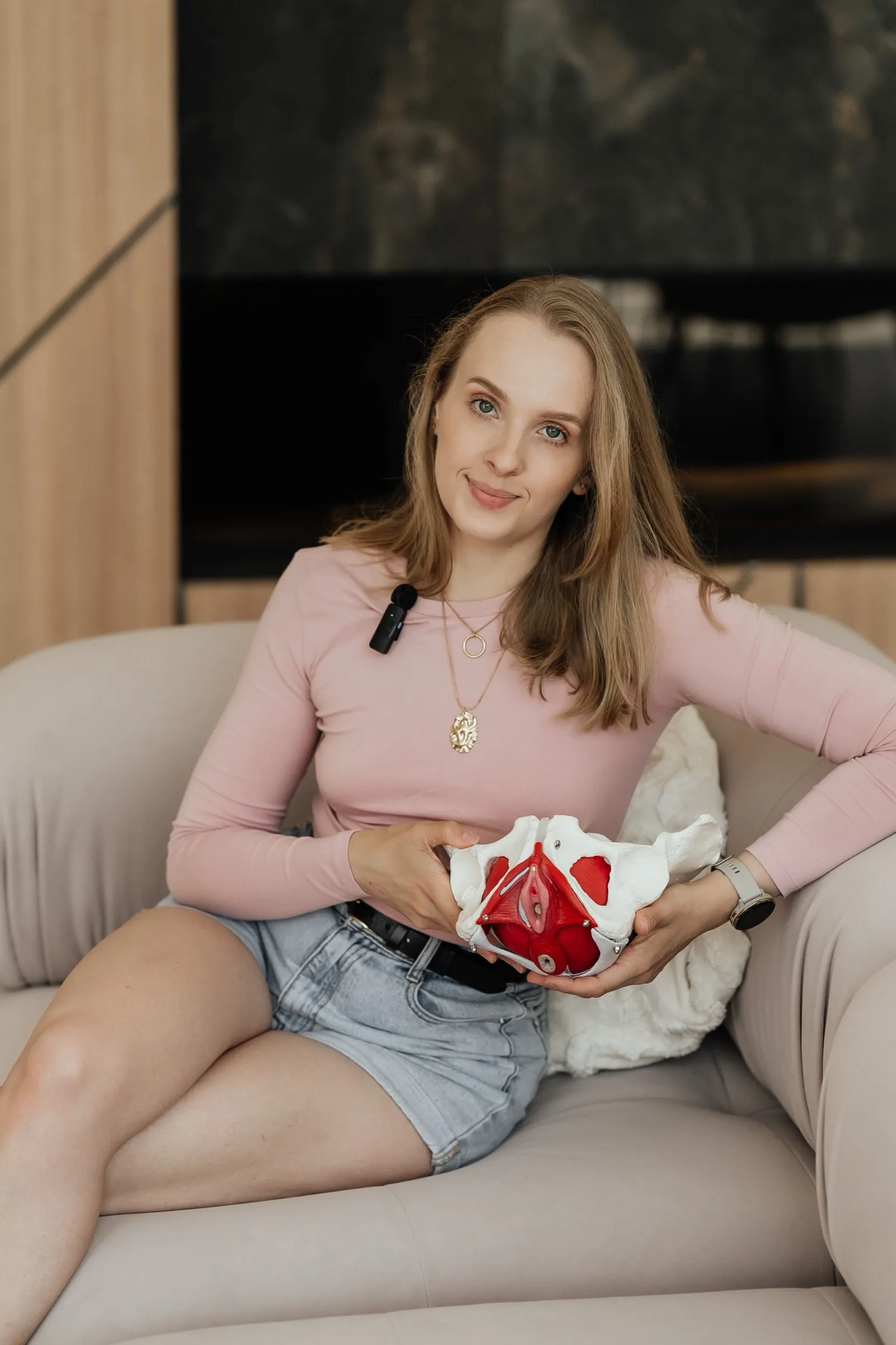 Ольга Бойко тримає анатомічну модель тазу з червоними м'язами тазового дна